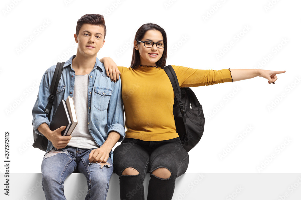 Students sitting on a panel and pointing to the side Students sitting on a panel and pointing to the side