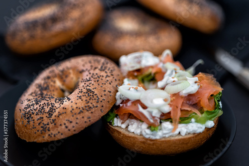 Salmon Lox Bagel with cream cheese and veggies on a dark setting photo