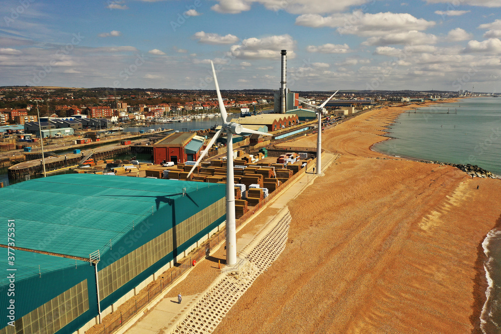 Fototapeta premium Looking from Southwick beach with Wind Turbines and Shoreham Power Station in view and Brighton in the distance.