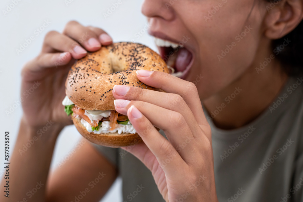 Woman eating a salmon lox bagel Woman eating a salmon lox bagel