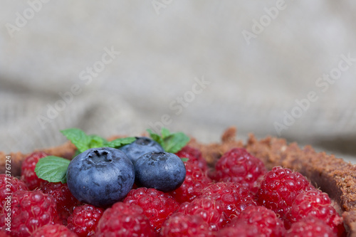 No-bake chocolate cake with cream cheese. Garnished with raspberries, blueberries and mint leaves.