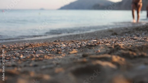 Woman walking by the seashore on sunset