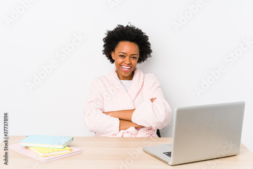 Middle aged african american woman working at home isolated laughing and having fun.