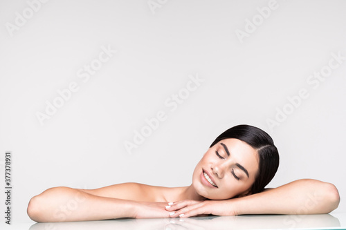 Spa. Face skincare beauty woman smiling happy. Beautiful attractive woman lying down on towel during skin care treatment isolated on white background.