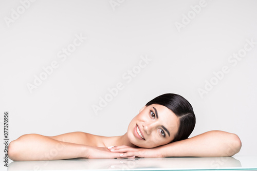 Young pretty woman cosmetics and skincare isolated on gray background