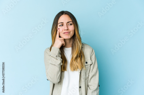 Young caucasian woman isolated on blue background crying, unhappy with something, agony and confusion concept.