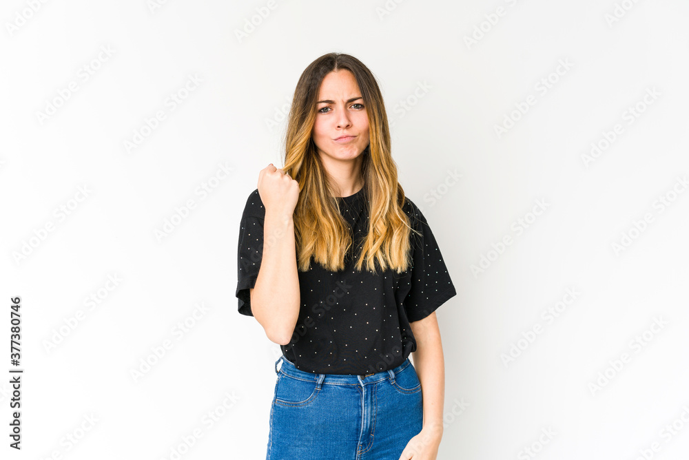 Young caucasian woman isolated on white background showing fist to camera, aggressive facial expression. Young caucasian woman isolated on white background showing fist to camera, aggressive facial expression.
