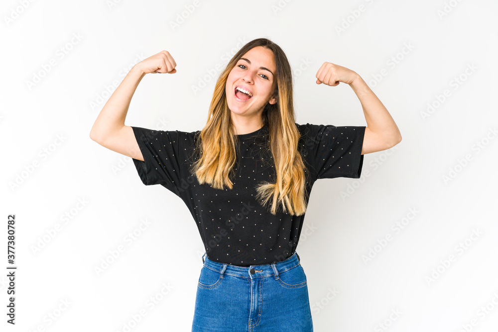 Young caucasian woman isolated on white background showing strength gesture with arms, symbol of feminine power Young caucasian woman isolated on white background showing strength gesture with arms, symbol of feminine power