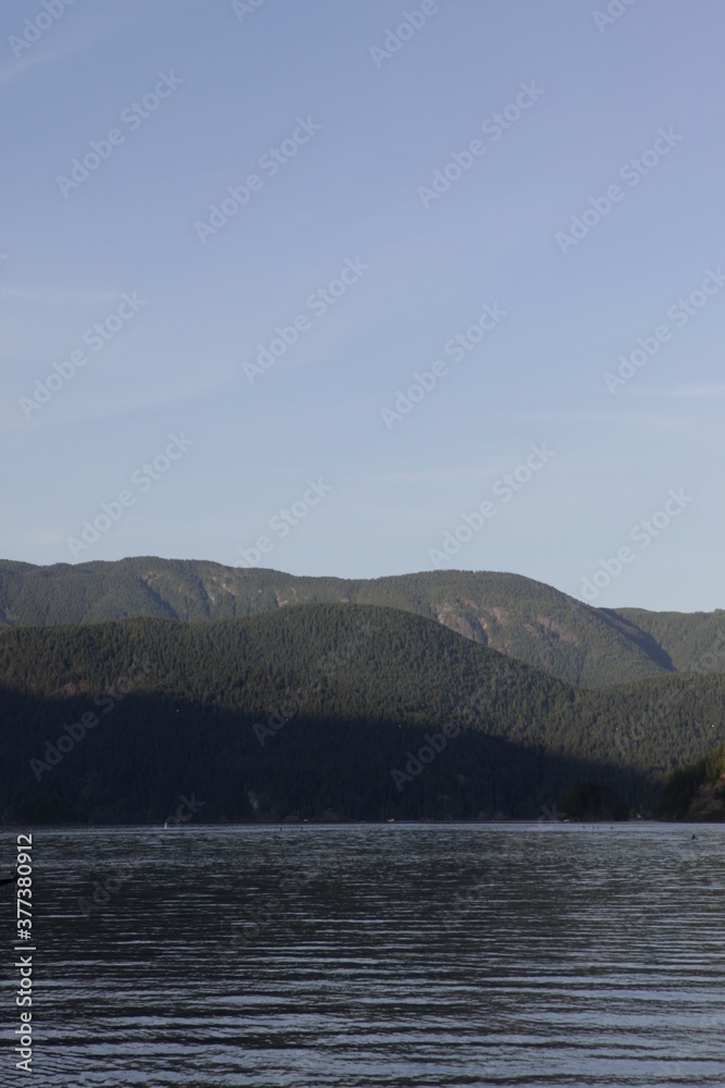 Calm lake and hills in a blue sky