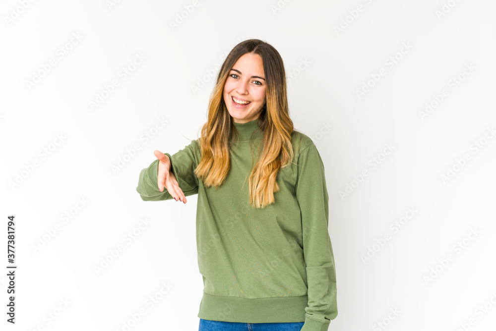 Young caucasian woman isolated on white background stretching hand at camera in greeting gesture. Young caucasian woman isolated on white background stretching hand at camera in greeting gesture.