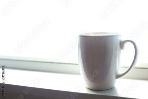 Coffee mug on a bright white windowsill