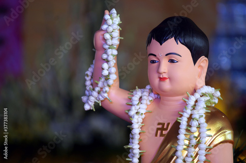 Buddha's Birthday statue with wreath in hand