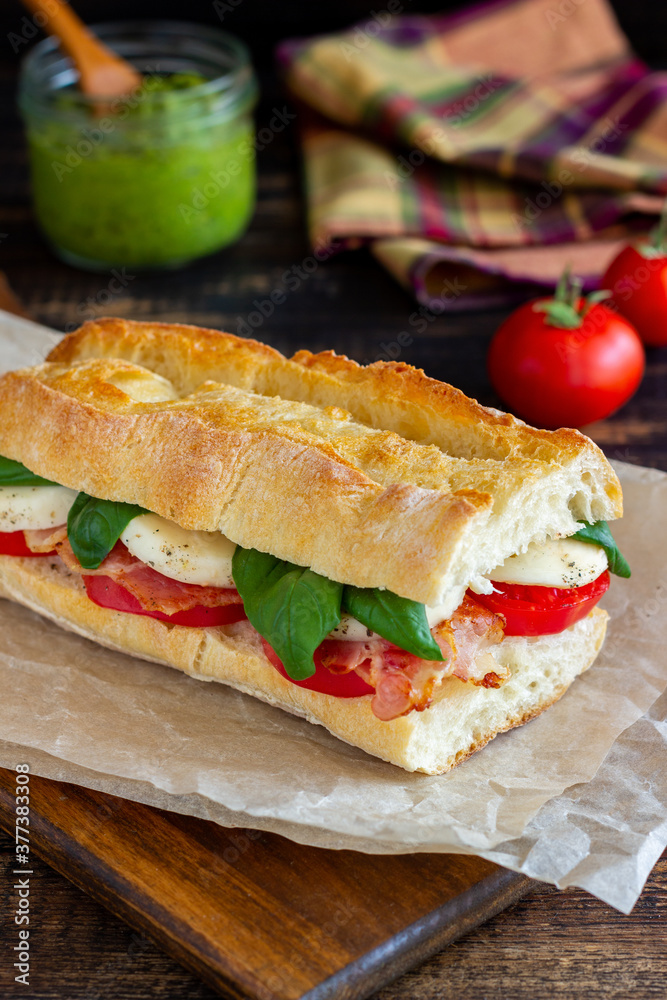 Caprese sandwich with tomatoes, mozzarella, basil and bacon. Healthy eating. Italian cuisine. Caprese sandwich with tomatoes, mozzarella, basil and bacon. Healthy eating. Italian cuisine.