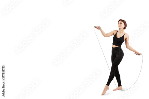 young beautiful woman in black leggings and top doing fitness and yoga indoors, on a white background, isolate