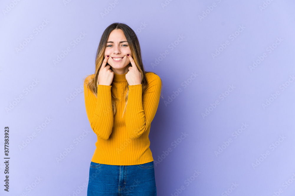 Young caucasian woman isolated on purple background doubting between two options. Young caucasian woman isolated on purple background doubting between two options.