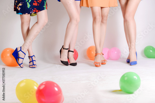 beauty legs in colorfull shoes white background, balloon.