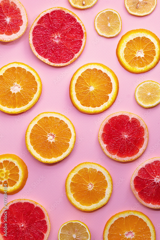 Round slices of grapefruit, orange and lemon on a pink background Round slices of grapefruit, orange and lemon on a pink background