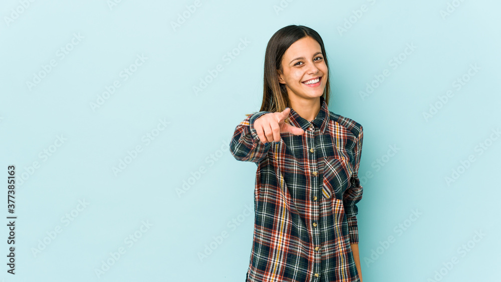 Young woman isolated on blue background cheerful smiles pointing to front. Young woman isolated on blue background cheerful smiles pointing to front.
