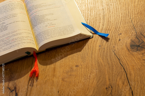 Open catholic missal book on a wooden desk background. Faith, religion gospel, and spirituality concept photo