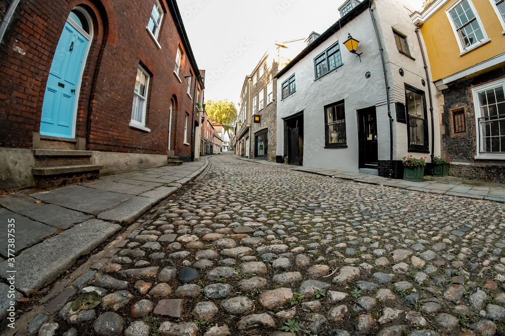 Low down worm eye view up a medieval cobblestone street in the city of Norwich, Norfolk