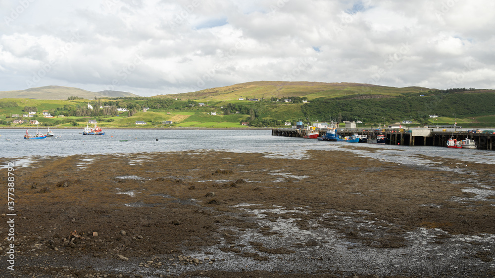 View of Uig bay, harbour and pier on the Isle of Skye, Scotland, at low tide.