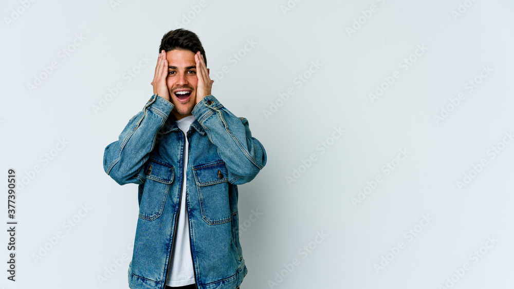 Young caucasian man isolated on white background having fun covering half of face with palm. Young caucasian man isolated on white background having fun covering half of face with palm.