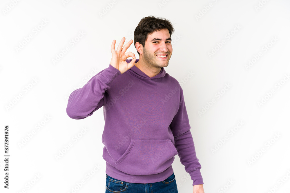 Young man isolated on white background cheerful and confident showing ok gesture. Young man isolated on white background cheerful and confident showing ok gesture.