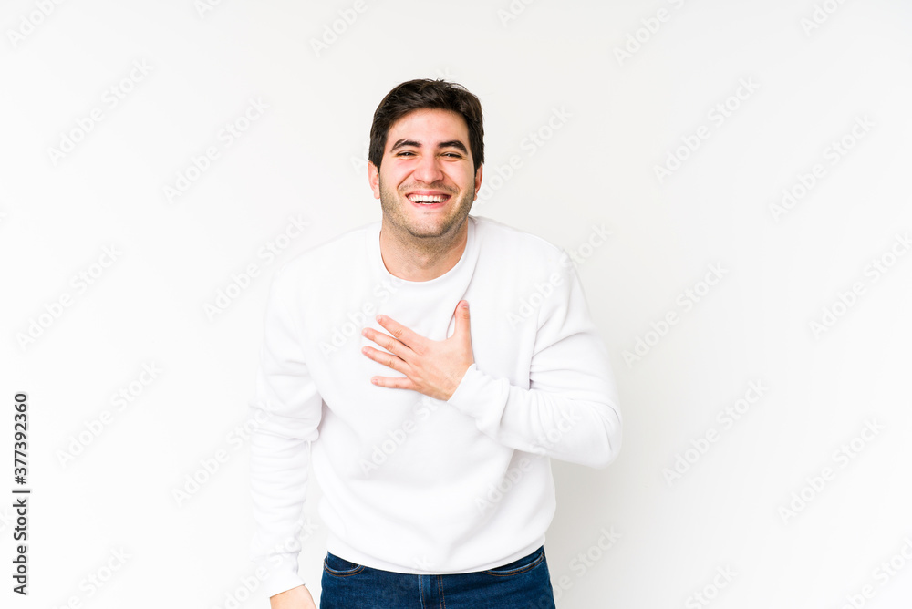 Young man isolated on white background laughs out loudly keeping hand on chest. Young man isolated on white background laughs out loudly keeping hand on chest.
