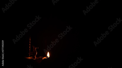 Oil lamp lit against dark background with copy space for Diwali greetings. Simple, aesthetic, calm visual without distraction