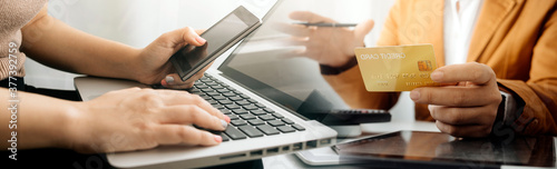 businesswoman hand using smart phone,mobile p payments online shopping,omni channel,digital tablet docking keyboard computer at office in sun light