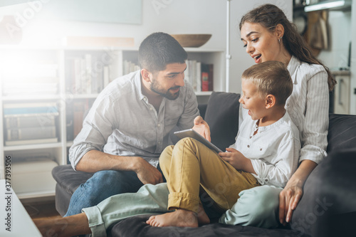 cute young family spending time together using tablet computer at home