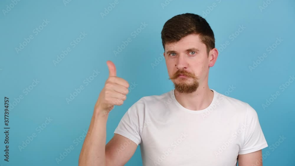 Young man showing okay hand sign and winking as if approving suggestion, millennial guy completely agree and support, dressed in white t-shirt, isolated on blue studio background with copy space Young man showing okay hand sign and winking as if approving suggestion, millennial guy completely agree and support, dressed in white t-shirt, isolated on blue studio background with copy space