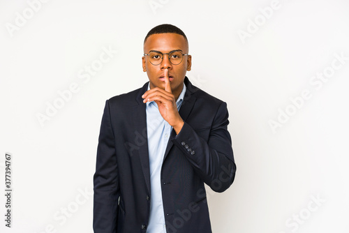 Young business latin man isolated on white background keeping a secret or asking for silence.