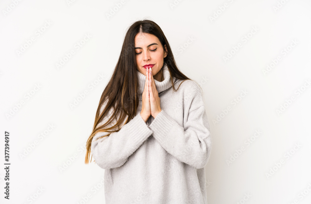 Young caucasian woman isolated on a white background holding hands in pray near mouth, feels confident. Young caucasian woman isolated on a white background holding hands in pray near mouth, feels confident.
