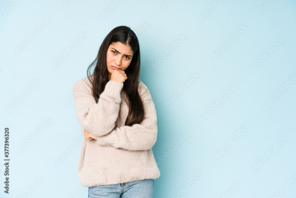 Young indian woman isolated on blue background tired of a repetitive task. Young indian woman isolated on blue background tired of a repetitive task.