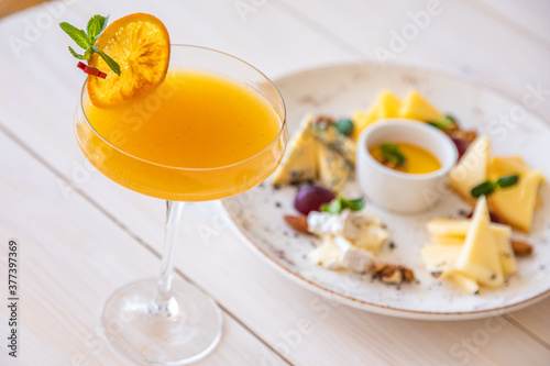 orange cocktail on a white background. decorated with a slice of dry orange