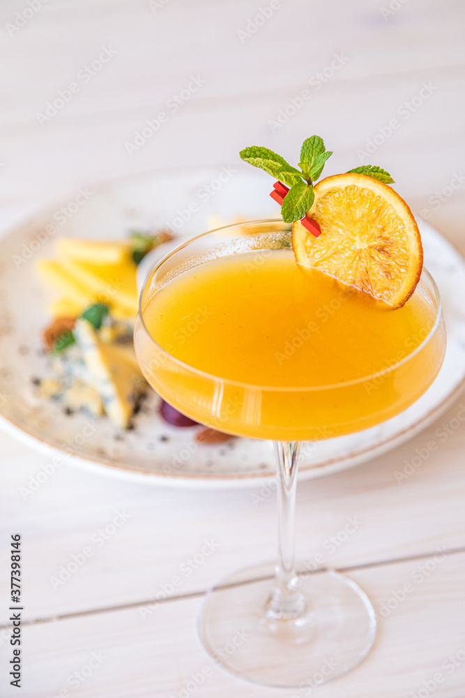 orange cocktail on a white background. decorated with a slice of dry orange orange cocktail on a white background. decorated with a slice of dry orange