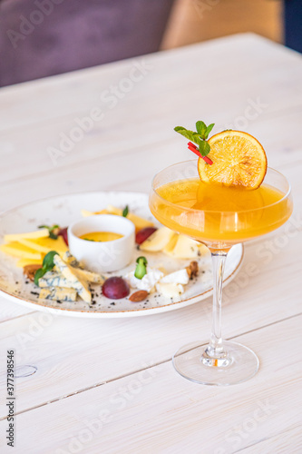 orange cocktail on a white background. decorated with a slice of dry orange