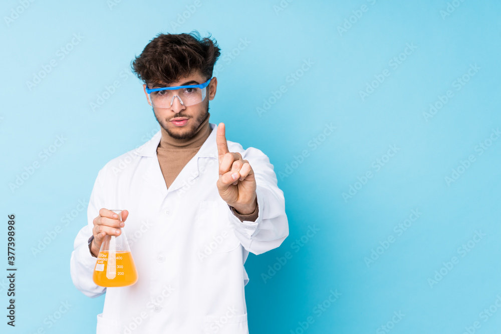 Young arab scientific man isolated showing number one with finger. Young arab scientific man isolated showing number one with finger.