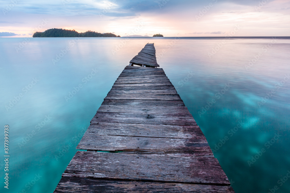 Obraz premium Old wooden pier in Indian ocean. Tropic island. Tranquil sunset landscape 