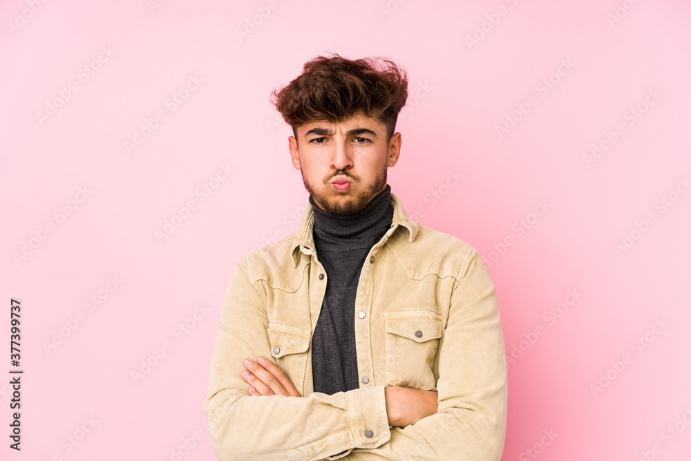 Young arabian man posing in a background isolated blows cheeks, has tired expression. Facial expression concept. Young arabian man posing in a background isolated blows cheeks, has tired expression. Facial expression concept.