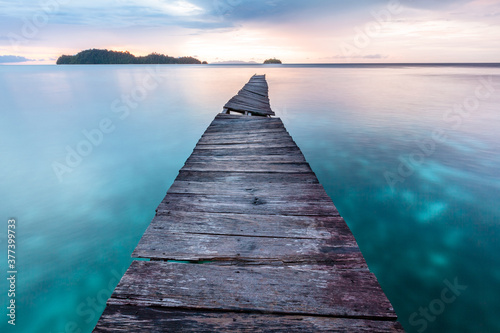 Old wooden pier in Indian ocean. Tropic island. Tranquil sunset landscape  photo