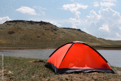 A red tent on the river bank.