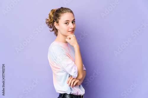 Young caucasian woman on purple background smiling happy and confident, touching chin with hand.