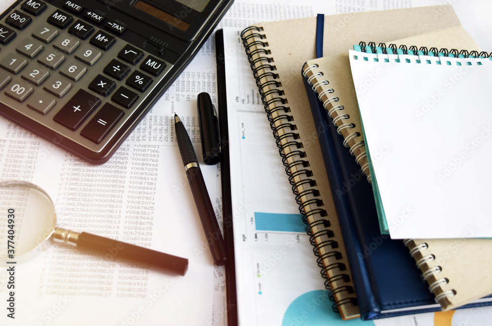 Business documents on an office desk with a calculator and pencil as a business concept of a workspace. With cloud exposure Business documents on an office desk with a calculator and pencil as a business concept of a workspace. With cloud exposure