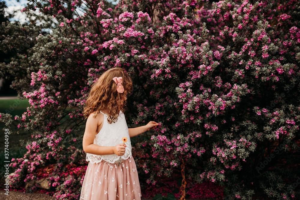 Young girl surrounded by purple flowers outside on summer day Young girl surrounded by purple flowers outside on summer day