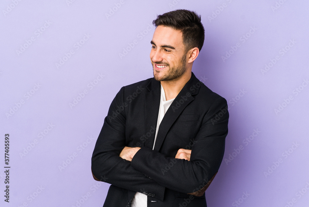 Young caucasian man isolated on purple background smiling confident with crossed arms. Young caucasian man isolated on purple background smiling confident with crossed arms.
