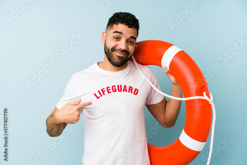 Young latin lifeguard man isolated pointing with finger at you as if inviting come closer.