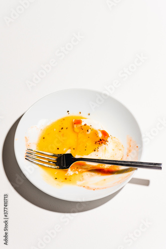 Half eaten fried egg with hot sauce