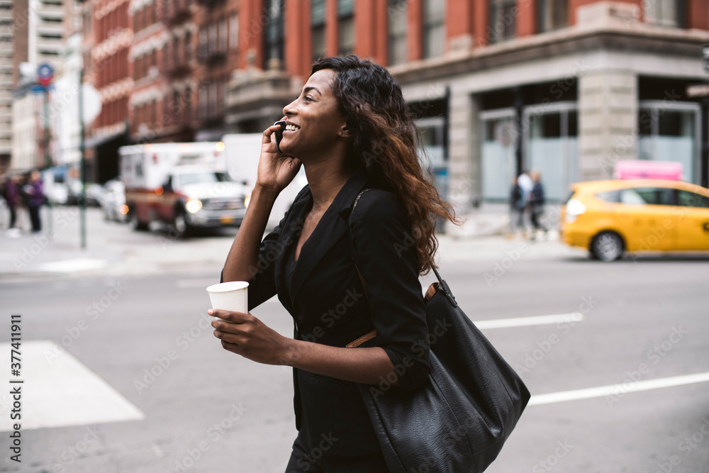 Happy young businesswoman walking and talking on the phone in New York City Happy young businesswoman walking and talking on the phone in New York City